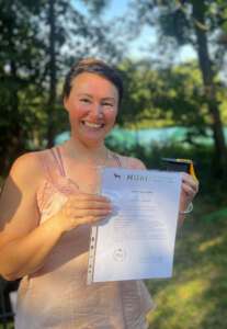HUni-Trainerin Micha Wiest mit Zeugnis der Hundetrainerausbildung HUni München